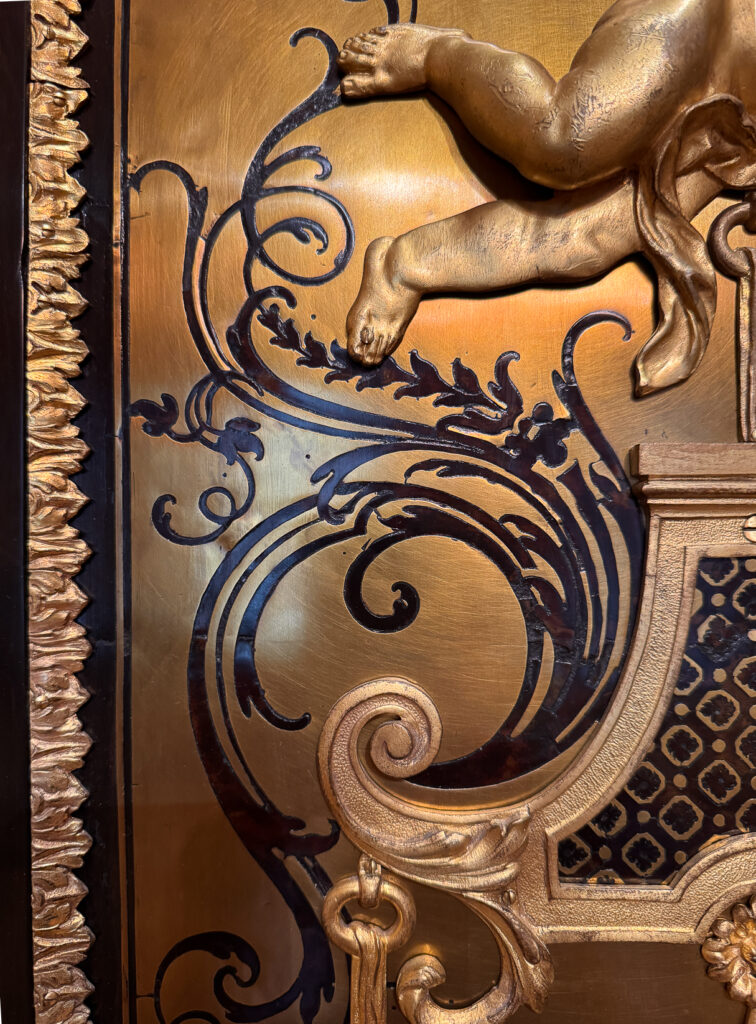Detail of a large cabinet with a clock attributed to Charles Andre Boulle, 18th century French with heavy ormolu detail and brass and ebony marquetry